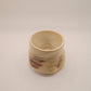 Small ceramic cup with marbled design on a plain background